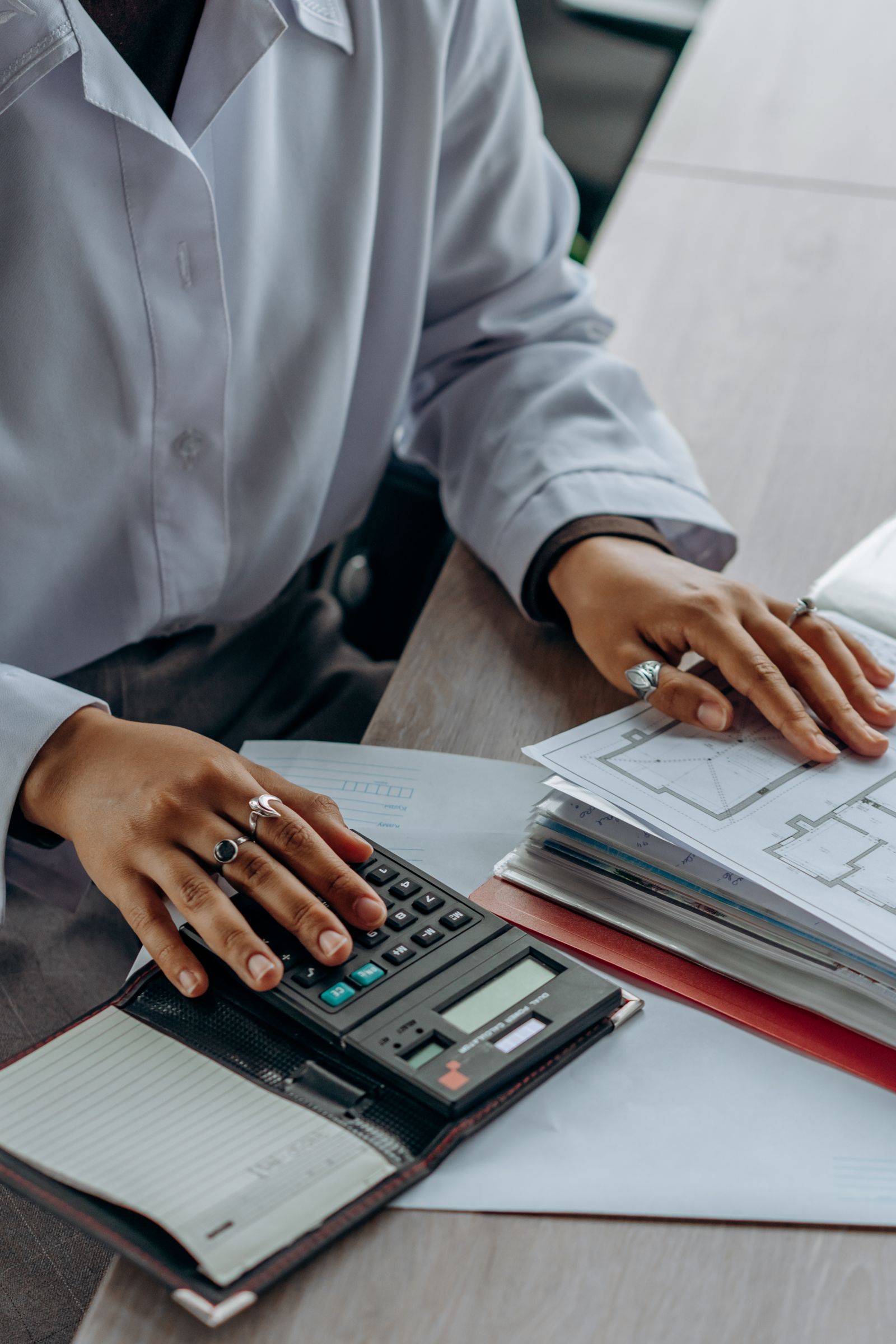 Professional reviewing accounting records with a calculator
